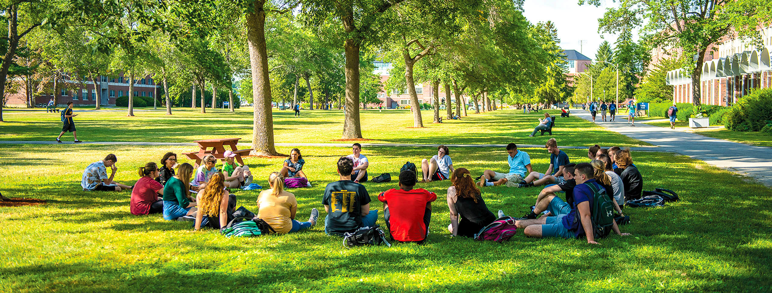 A photo of students attending class outside on UMaine's Mall