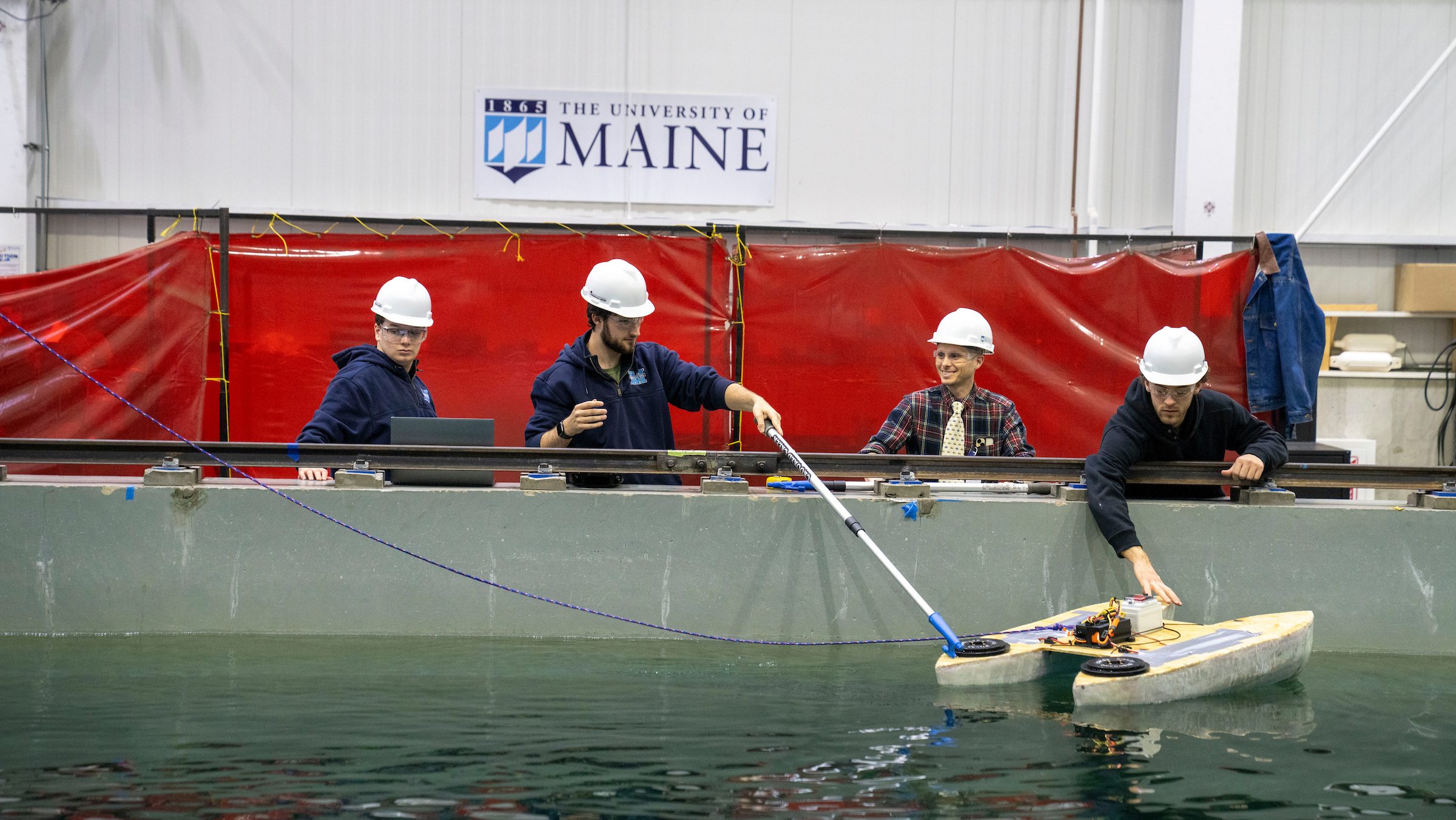 A photo of four students with the Robo Boat