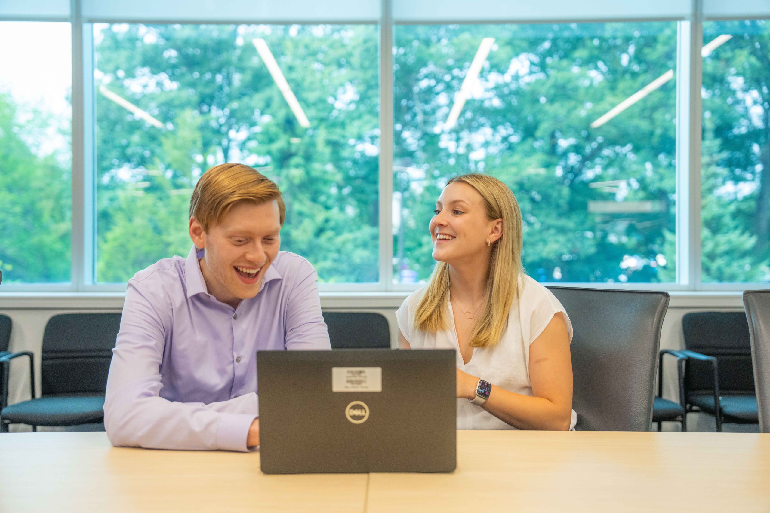 Students smiling and working on a computer