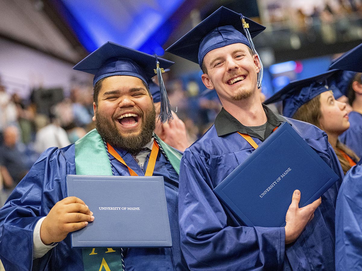 A photo of two people graduating from UMaine