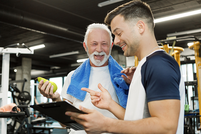 Two adults smiling and looking at a clipboard