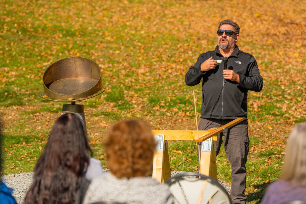 A photo of a man in a field unveiling new sundial at Webster Park in Orono, maine 