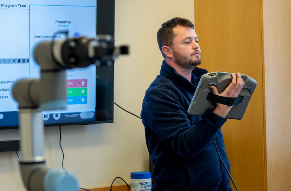 Image of advanced manufacturing center robot trainer leading a high-school workshop
