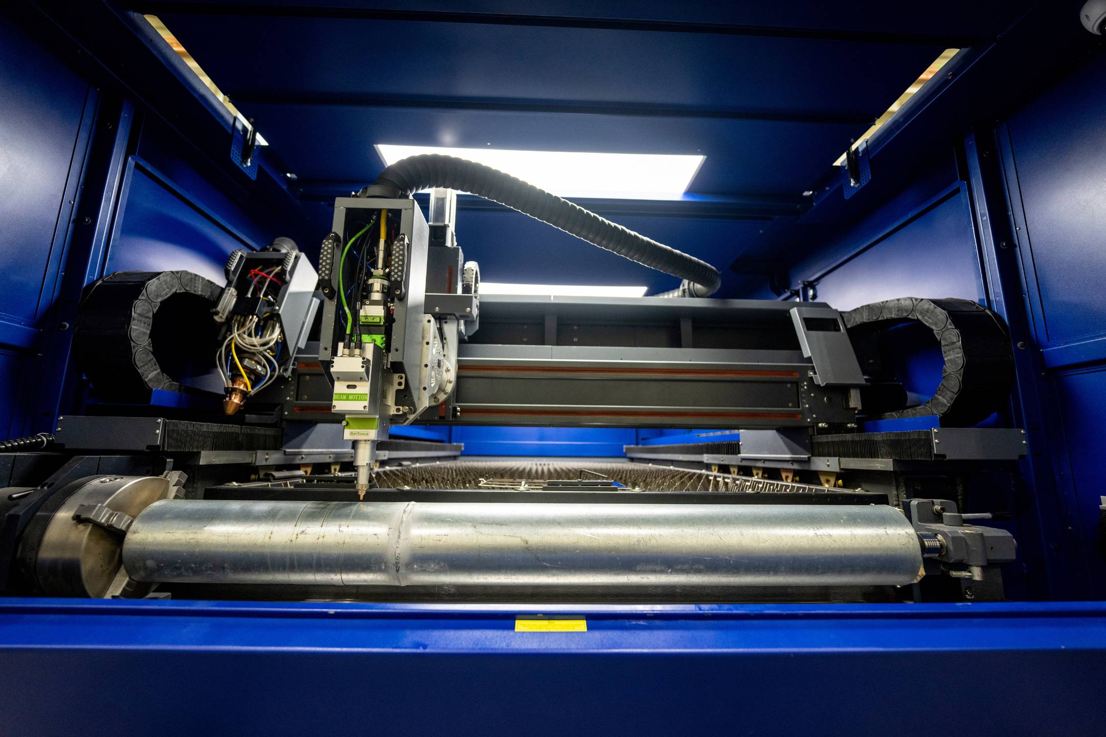 Close-up of a CNC laser cutting machine in the University of Maine’s Advanced Manufacturing Center workshop, used for precision metal fabrication and prototyping.