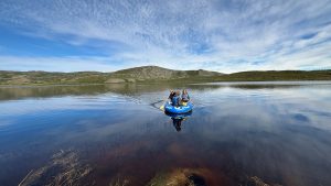 A photo of two people kayaking on the waters of a lake near Kangerlussuaq, Greenland