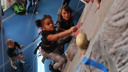 Young girl climbing indoor rock wall