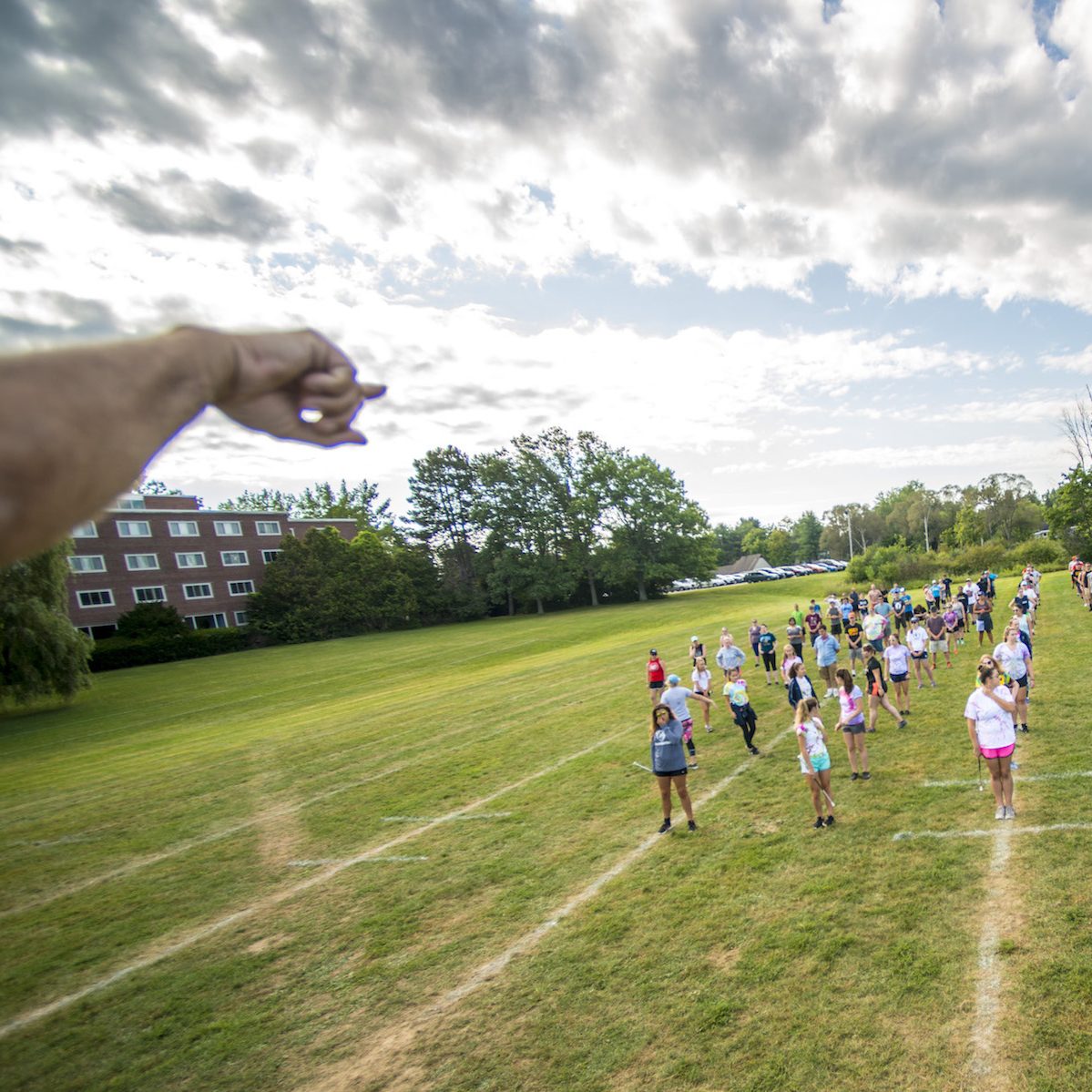 marching band director pointing something out to band standing in warmup block