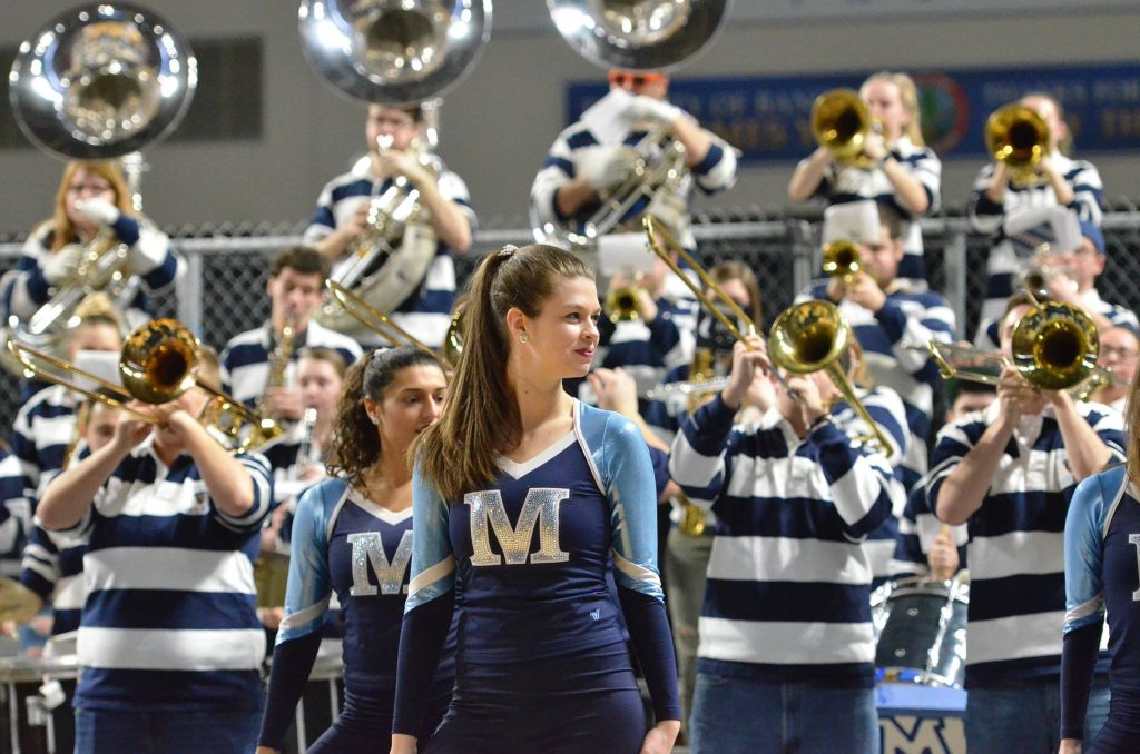 member of the dance team in the foreground, pep band in the background