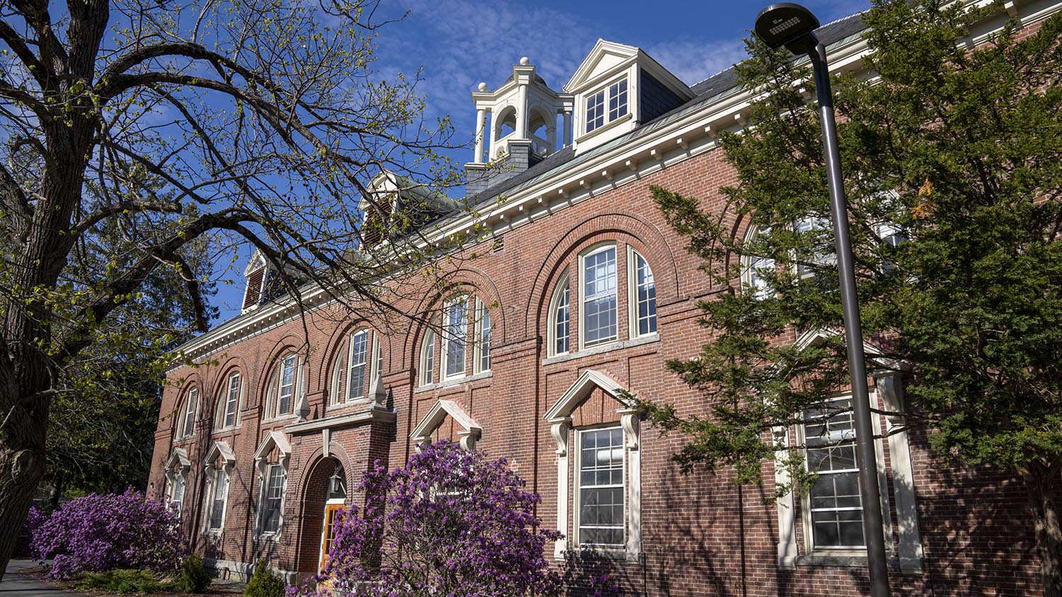 A photo of the exterior of Alumni Hall in spring