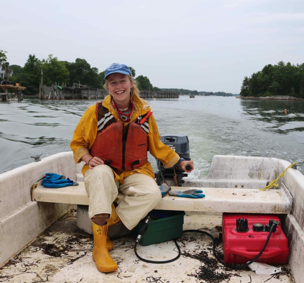 Esther Martin smiling while steering a skiff