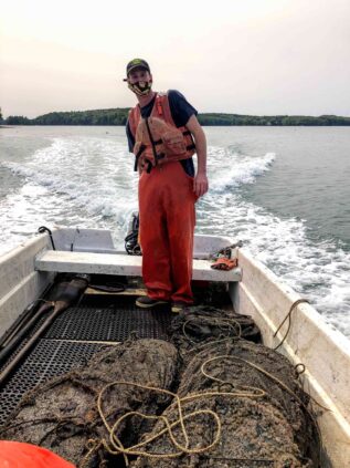 Student steers boat with aquaculture nets