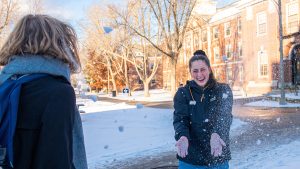 Two UMaine students play in the snow.