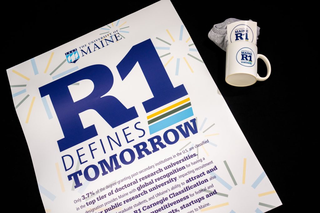 A photo of an R1 Defines Tomorrow poster and mugs.