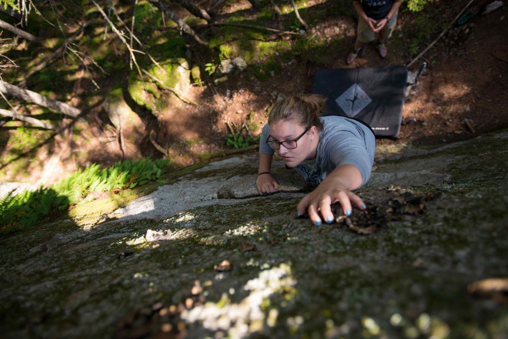 Photo of a rock climber scaling a rock face, looking down from above