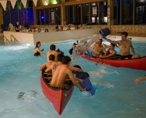 Photo of New Balance Rec Center Pool with two red canoes filled with people.