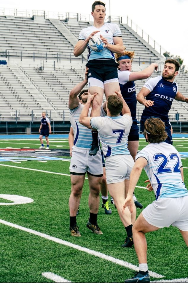 Members of the Men's Rugby Club play on the field