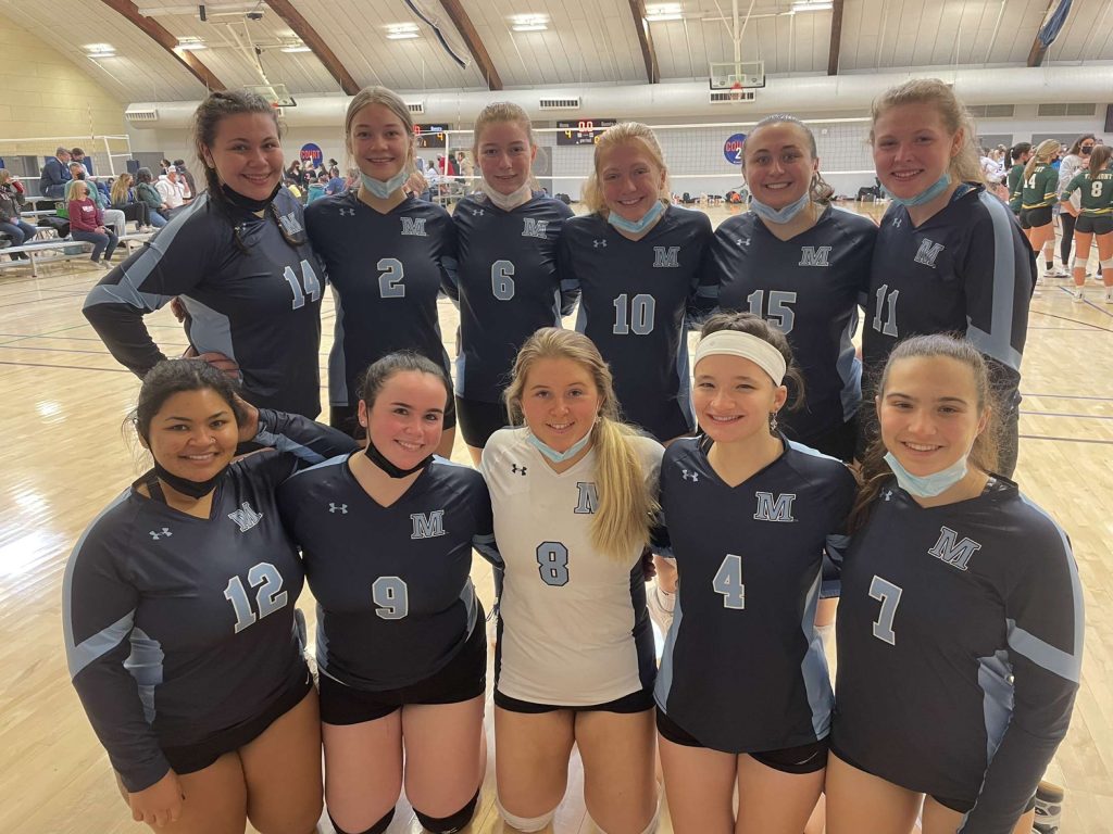 A group photo of the UMaine Womens Club Volleyball team assembled on the indoor court.