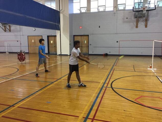 A student playing badminton on the indoor court