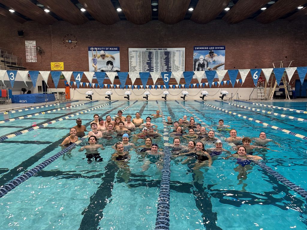 Group photo of UMaine swim club, gathered together in the pool