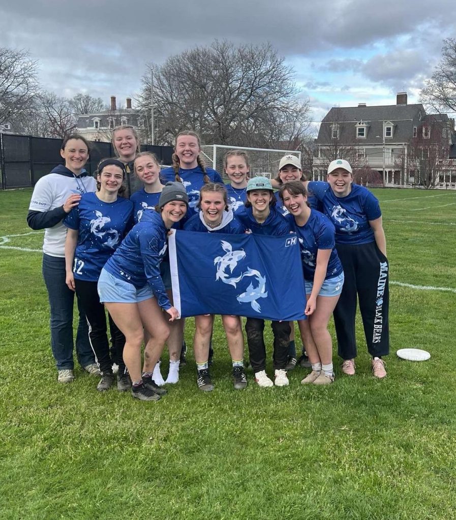 Women's Ultimate Frisbee club group photo, taken outdoors on the UMaine campus