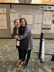 Caroline, and Eleanor hugging with a research poster at ADAA
