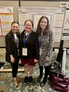 Caroline, Dr. Blossom, and Eleanor with a research poster at ADAA