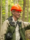Picture of Bill Livingston, in the woods with hard hat