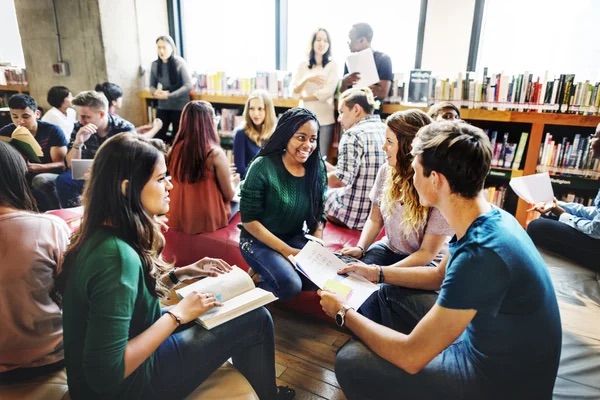 Students sitting on bean bags in a library talking about books