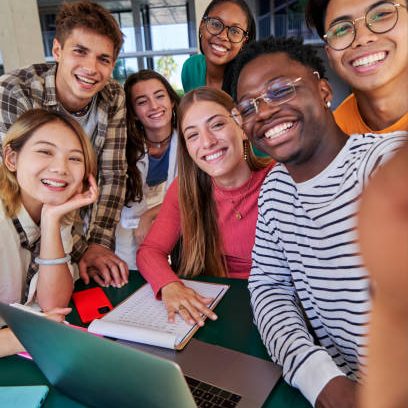 Vertical photo of a group of multiracial students taking a selfie while gathering to study together at campus university. Copy space.