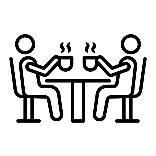 two icons sitting at a table and drinking coffee