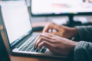 person typing on a laptop - to depict writing