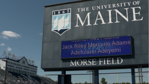 A screenshot of a video showing graduates' names on the Morse Field scoreboard