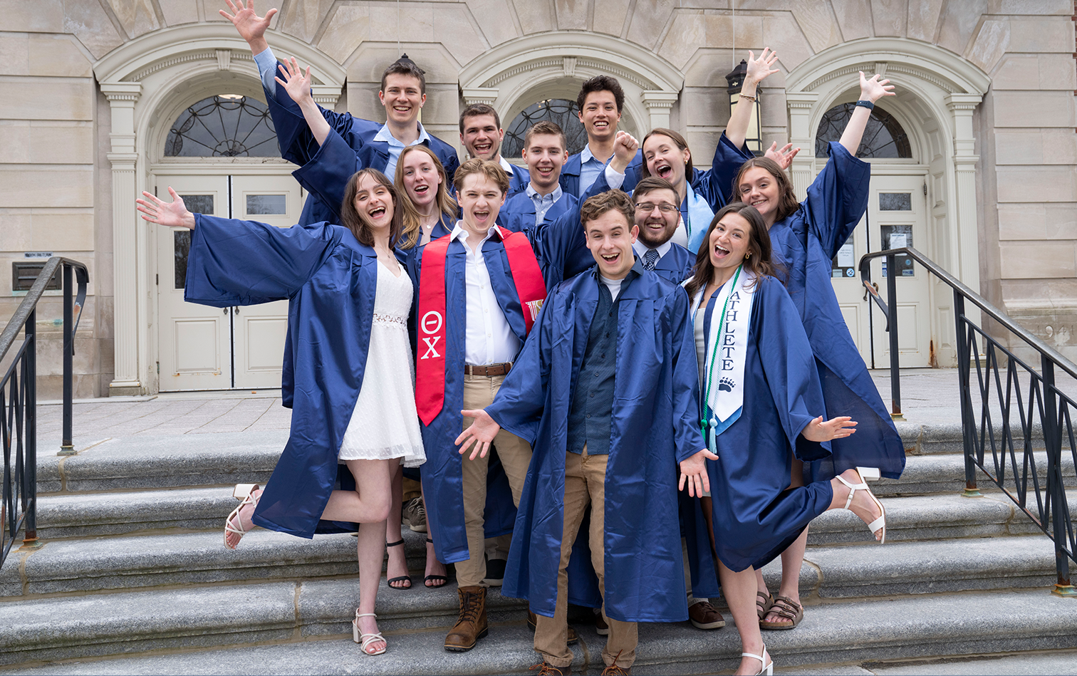 A photo of graduates on the library steps