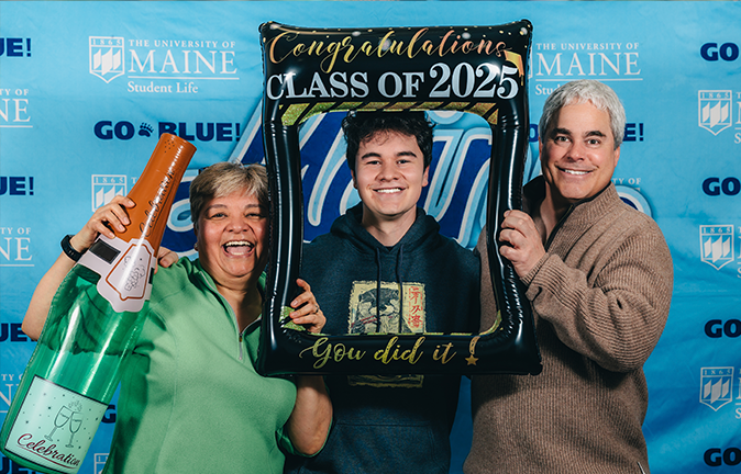 A photo of a graduate with his parents