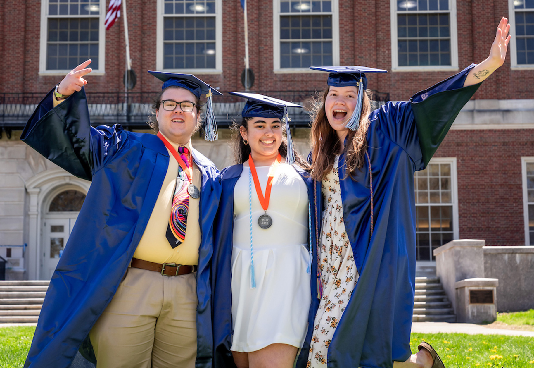 A photo of three graduates in front of Fogler