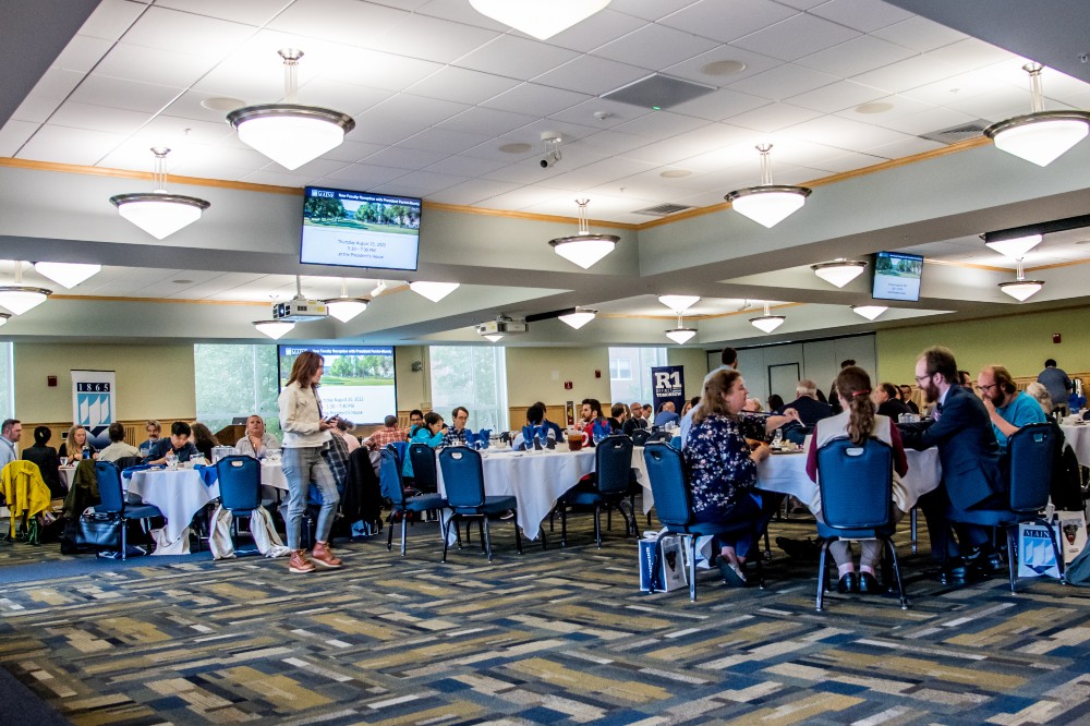 Conference event with people sitting around tables enjoying each others company