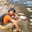 Photo of researcher sitting by water