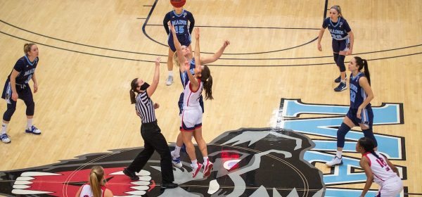 women going for the basketball on UMaine court