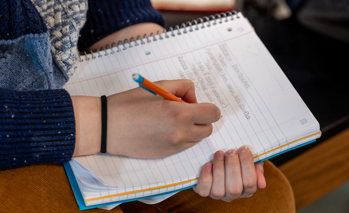 A photo of someone writing in a notebook