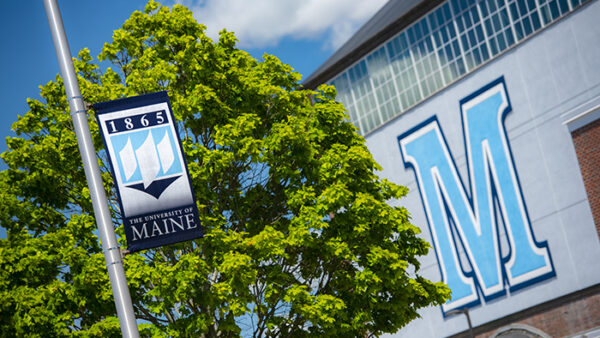 sunny photo of UMaine M on field house