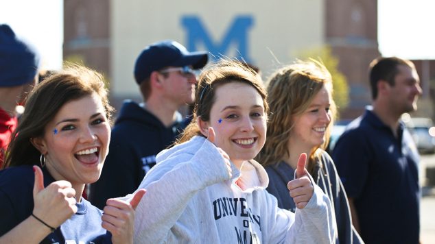 Students at UMaine Sporting Event giving a thumbs up