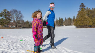 instructor teaching child to ski