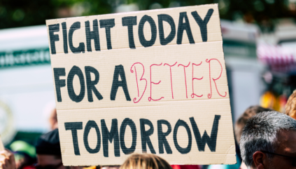 Cardboard sign which reads "Fight today for a better tomorrow"