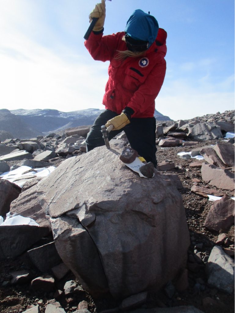 Collecting a rock sample that will later be dated using surface exposure-age dating methods.