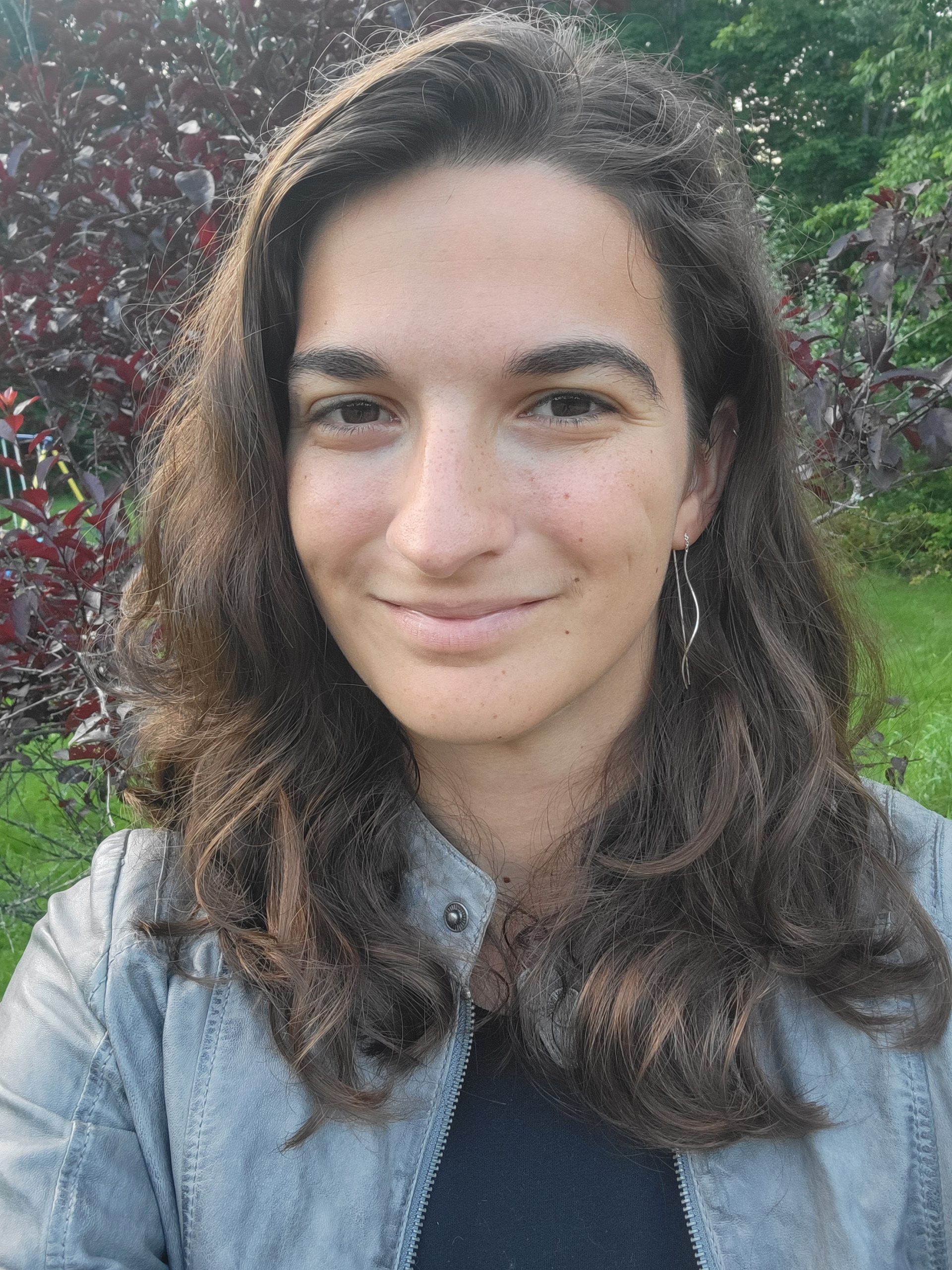 Alyson East smiling in front of a tree