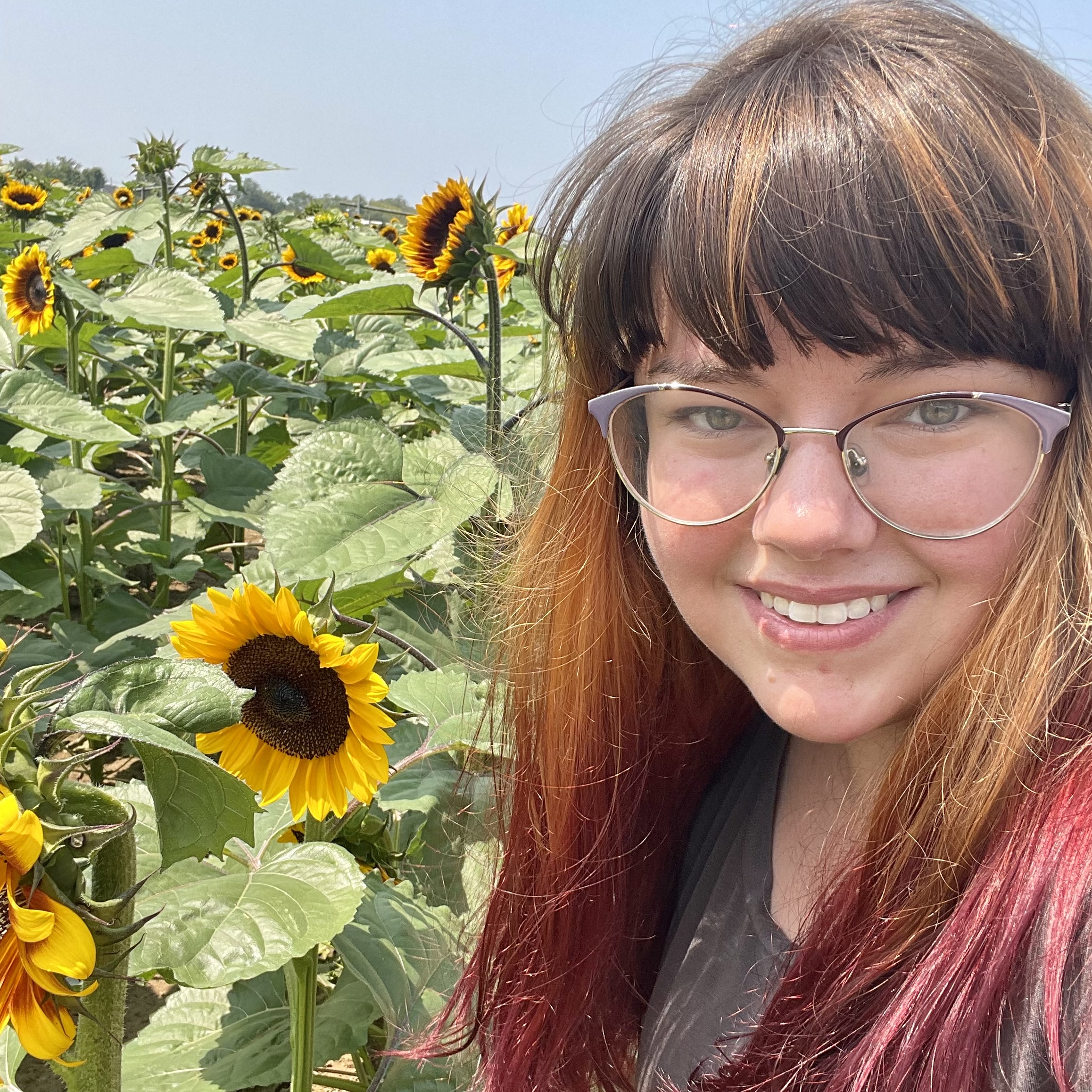 Monica Miles posing in front of sunflowers