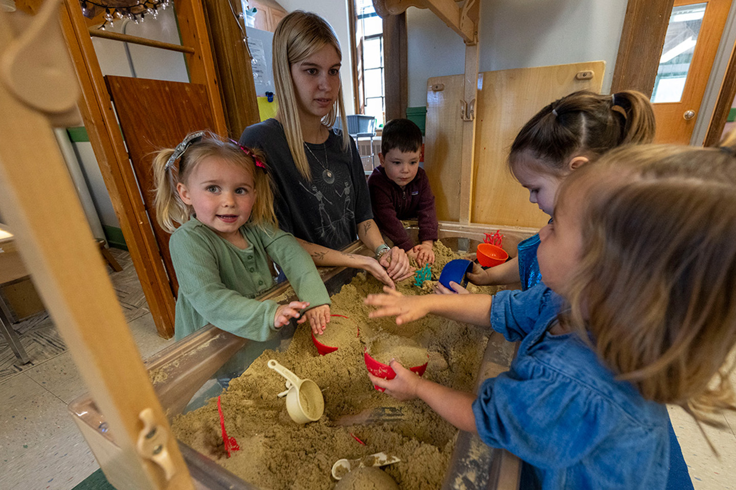 Kids and teachers playing in a sand box