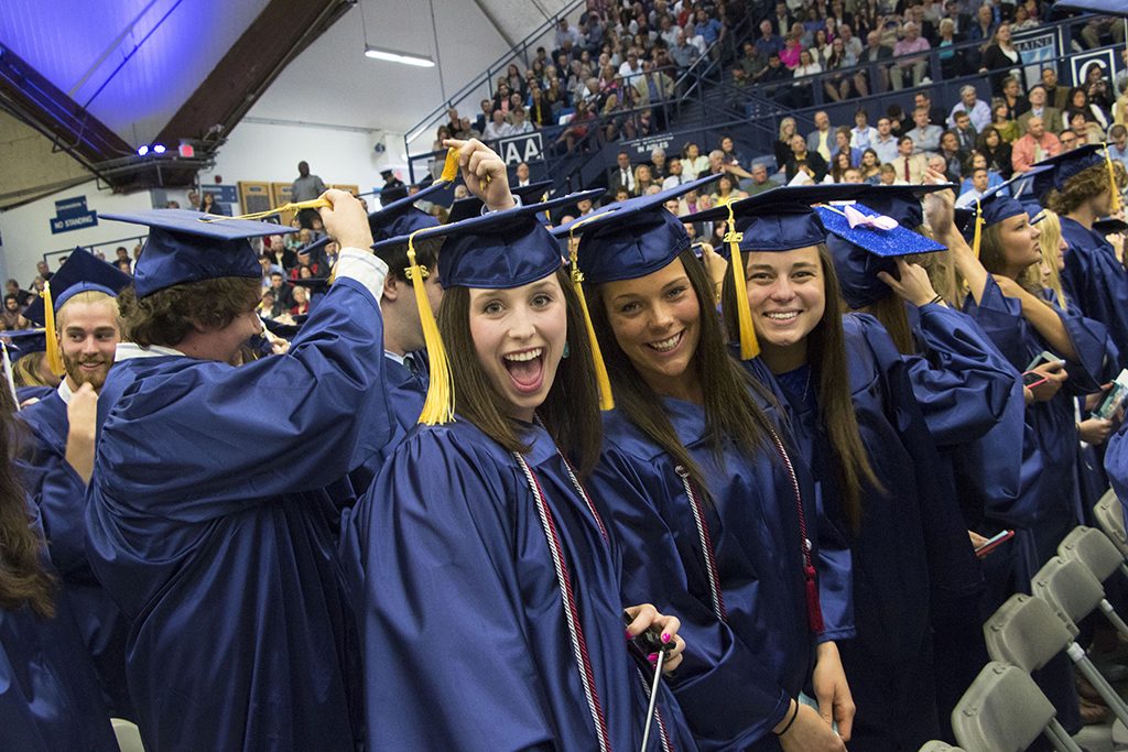 A photo of students graduating at commencement, in caps and gowns.