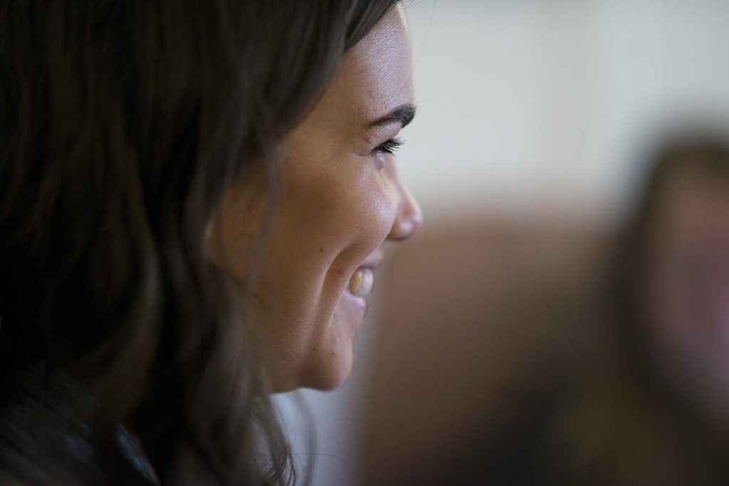 A close up of a smiling woman looking off-camera