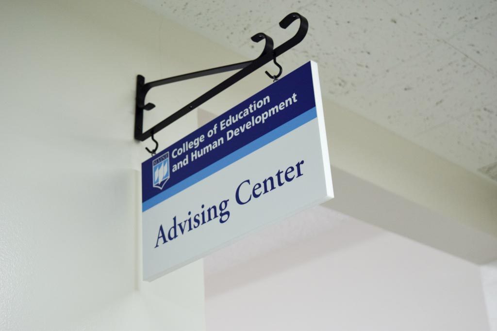 Photo of the Advising Center sign inside Shibles Hall's first floor hallway